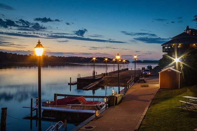 sunset, water, illuminated, sun, sky, street light, lighting equipment, tranquility, sunlight, reflection, scenics, built structure, tranquil scene, pier, lens flare, nature, beauty in nature, lake, sunbeam, architecture