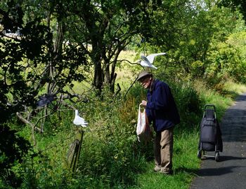 Man holding umbrella in forest