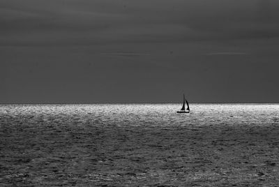 Silhouette man standing in sea against sky