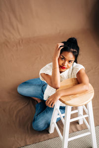 Young woman sitting on chair at home