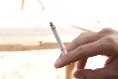 Close-up of hand holding cigarette