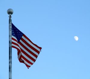 Low angle view of flag against clear blue sky