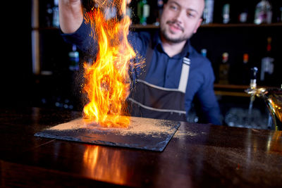 Young man with fire on table