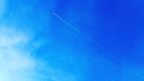 Low angle view of vapor trail against clear blue sky