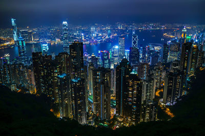 Illuminated cityscape against sky at night