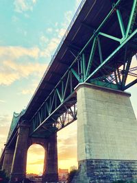 Low angle view of bridge against cloudy sky