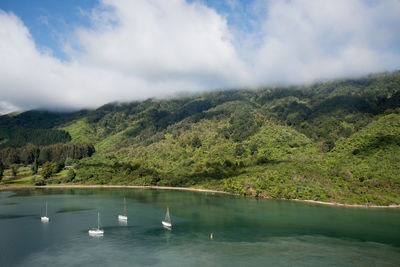 Scenic view of lake by mountains against sky