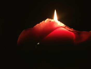 Close-up of illuminated candle in darkroom