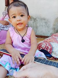 Cute girl sitting on bed at home