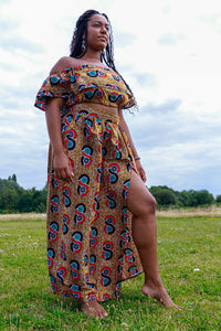 Midsection of woman standing on field against sky