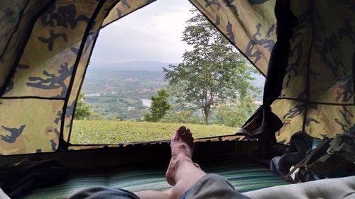 Low section of man relaxing by window