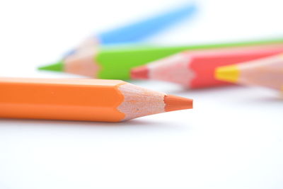 Close-up of multi colored pencils against white background