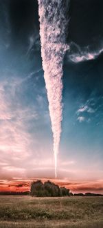 Low angle view of vapor trails on field against sky