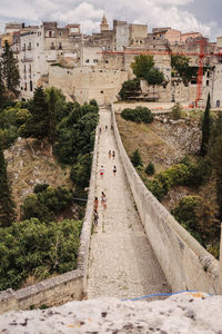 High angle view of people walking on road amidst buildings in city