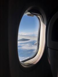 View of cloudy sky seen through airplane window