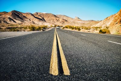 Surface level of road on desert against sky