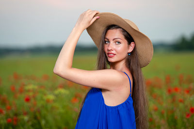 Portrait of young woman standing on field