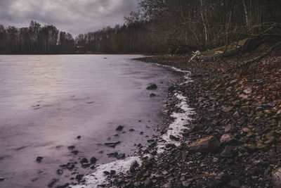 Scenic view of lake against cloudy sky