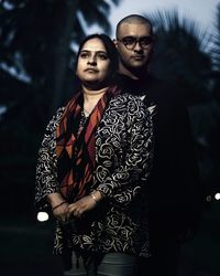 Front view of man and woman standing against plants