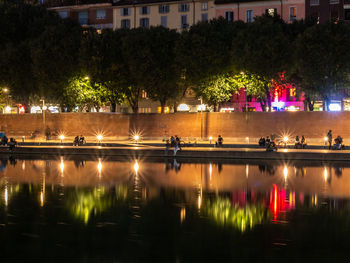 Scenic view of lake in city at night