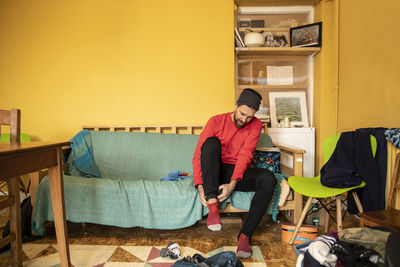 Man wearing socks sitting on sofa at home