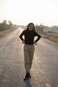 Portrait of woman standing on road against the sky