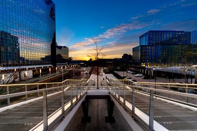 Bridge over canal in city against sky during sunset