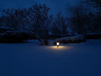 Snowy night landscape and light in the distance 