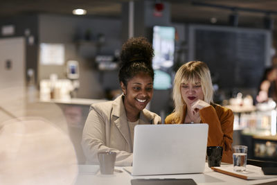 Female coworkers talking in cafe