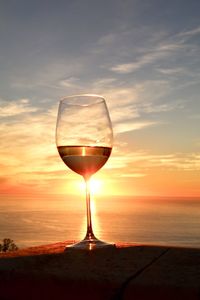 Wineglass against clear sky during sunset