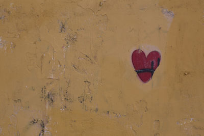 Close-up of heart shape on brick wall