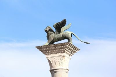 Low angle view of statue against blue sky