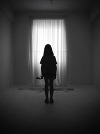 Silhouette of girl standing indoors