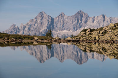 Scenic view of mountain range dachstein reflection in lake against clear blue sky