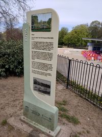 Information sign on railing against trees