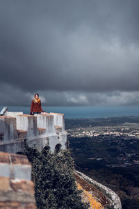 Buildings on rock against sky