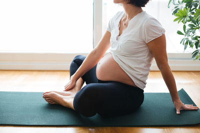 Midsection of woman sitting at home