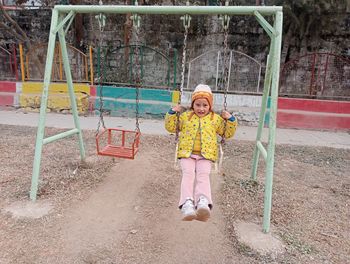 Full length of boy swinging at playground