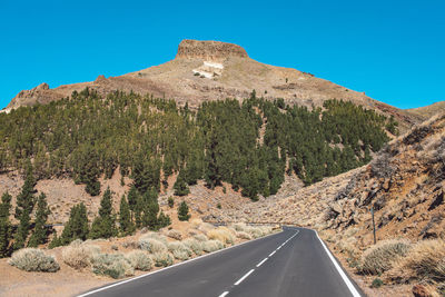 Road by mountain against clear sky