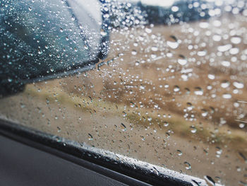 Close-up of wet glass window in car