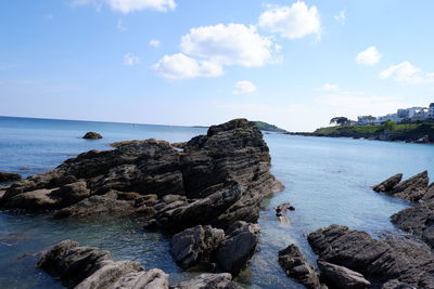 Rocks on sea shore against sky