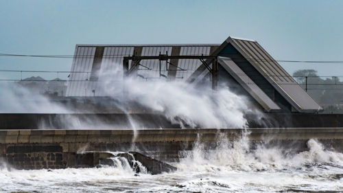 Water splashing in sea against clear sky