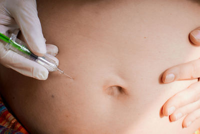 Midsection of woman holding syringe