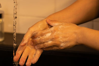 Close-up of woman hand on wet table