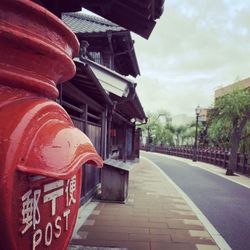 Footpath amidst buildings in city against sky