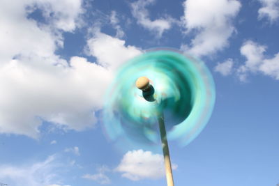 Close-up of spinning pinwheel against cloudy sky