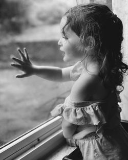 Side view of girl looking out a window