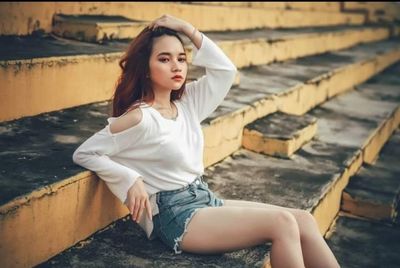 Portrait of beautiful young woman sitting outdoors