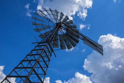 Low angle view of windmill against blue sky