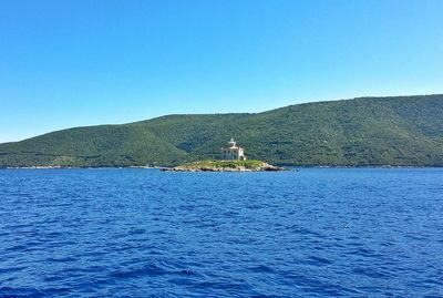 Scenic view of calm sea against clear blue sky